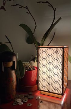 a table with two vases and some coins on top of it next to a potted plant