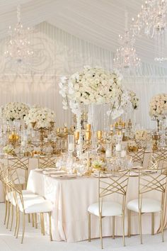 the tables are set up with white flowers and gold chairs for an elegant wedding reception