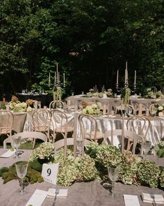 the tables are set up with silver cloths and white linens for an outdoor wedding