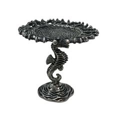 a metal tray with a seahorse on it's side and an intricate design in the middle