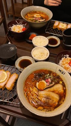 a table topped with bowls and plates filled with different types of food on top of it