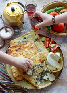 two hands reaching for food on a plate