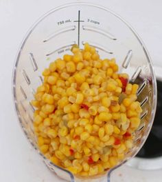 a blender filled with corn on top of a table