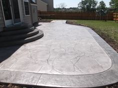 a concrete patio with steps leading up to the back door