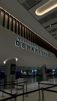 there is a large sign that says manchester airport departures on the wall above it