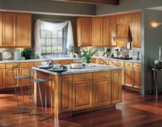 a large kitchen with wooden cabinets and stainless steel appliances, along with hardwood flooring