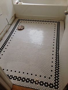 a bathroom with black and white tiles on the floor