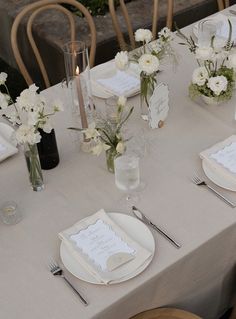 a table set with place settings and flowers