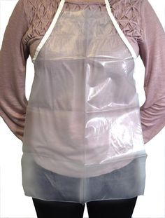 a woman with an apron on standing in front of a mannequin wearing a plastic bag