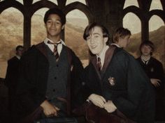 two young men standing next to each other in front of a building with arched windows