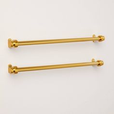 two gold - plated metal handles on white background