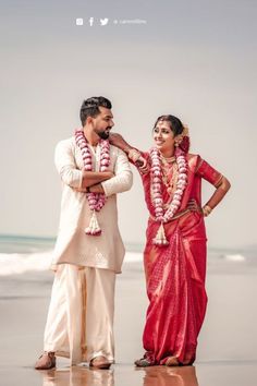 a man and woman standing next to each other on the beach