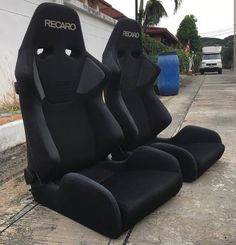 three black seats sitting on the side of a road