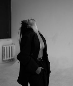 black and white photograph of a woman in a suit looking up to the sky with her eyes closed