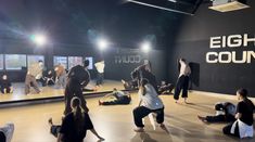 a group of people in a dance studio doing various moves on the floor with their feet up