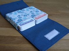 two folded books sitting on top of a wooden table