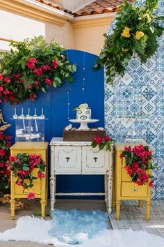 a room with blue and yellow walls decorated with potted plants on top of small tables