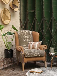 a living room filled with lots of furniture next to a green wall and potted plants