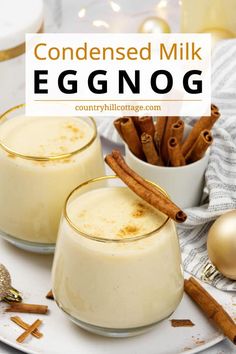 two glasses filled with eggnog on top of a white plate next to cinnamon sticks