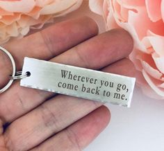 someone is holding a keychain that says wherever you go, come back to me