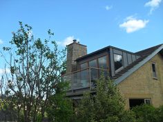 a large house sitting on the side of a lush green field next to a forest