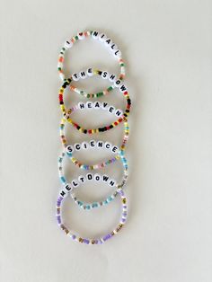 four bracelets with the words science written on them in different colors and sizes, arranged together