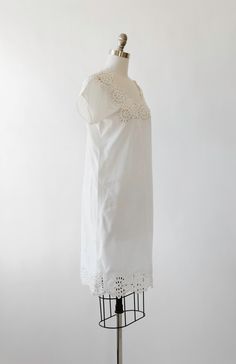 "Stunning simple 1900s Antique vintage cotton chemise slip dress Embroidered cutout bodice Pull over fit Great vintage condition, does has discoloration spots on back and slight staining on front (see photos) overall great condition for age. M e a s u r e m e n t s: Size: best fit S M Bust: 19\" Waist: 19 1/2\" Hips: 20 1/2\" Total Length: 40\" Sleeves: 9\" (from neck) ------------------------------------- +All Measurements are taking while garment is lying flat+ + Jewelry, belts, and any other Spring Cotton Dresses With Cutwork, Summer Vintage White Dress With Broderie Anglaise, Summer Vintage White Broderie Anglaise Dress, Elegant Cotton Dress With Cutwork Details, Summer Wedding Vintage Cotton Dress, Fitted Cotton Dress With Cutwork Hem, Fitted Summer Dress With Cutwork, Fitted Dress With Cutwork Hem For Daywear, Regency Style Cotton Dress For Spring