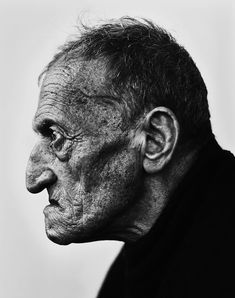 an old man with wrinkles on his face and neck, looking off to the side