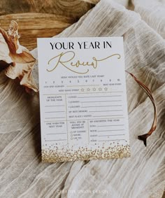 a card that says your year in review next to some dried leaves on a table