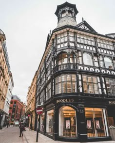 the corner of a street with buildings and people walking by