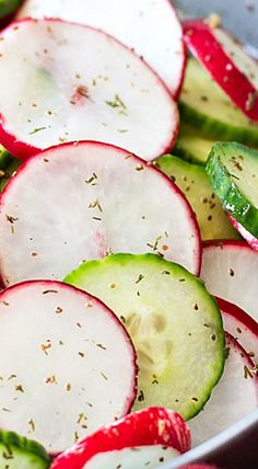 sliced radishes and cucumbers in a bowl with seasoning on top