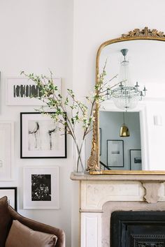 an instagram photo of a living room with pictures on the wall and a fireplace