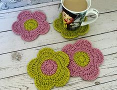 three crocheted coasters on a table with a cup of coffee