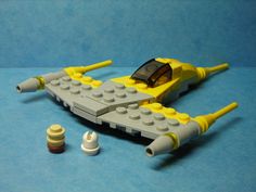 a lego model is laying on the ground with other toys around it, including a yellow and gray plane