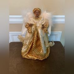 an angel figurine sitting on top of a table next to a white wall