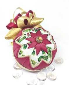 a red ornament with a gold bow on it