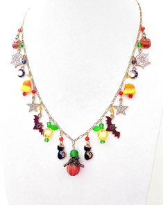 This happy and colorful Halloween charm necklace is handcrafted by myself and a one of a kind original.  The gold plated chain is 20 inches long with 17 drops containing  pumpkins, jack o lanterns, candy corn,  moons, stars, bats and lots of crystals so it sparkles as you move.  It contains an assortment of enamel charms, glass, acrylic and crystals.  If you need it shorter or longer just let me know, and I will adjust it to as close as possible to the size you desire. If you would like a charm Halloween Dangle Necklaces As Gifts, Halloween Dangle Necklace For Gift, Halloween Gift Dangle Necklace, Dangle Necklace For Halloween Gift, Fun Red Halloween Jewelry, Red Fun Halloween Jewelry, Fun Red Jewelry For Halloween, Bohemian Necklaces For Halloween Jewelry Making, Bohemian Necklace For Halloween Gift