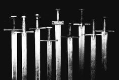 several swords are lined up against a black background