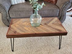 a table with a vase on it sitting in front of a couch