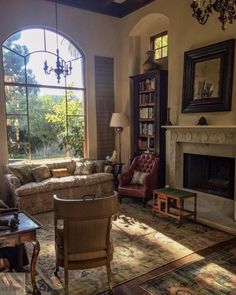 a living room filled with furniture and a fire place in front of a large window