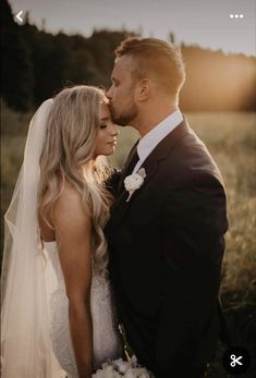 a bride and groom standing in a field at sunset with the sun shining down on them