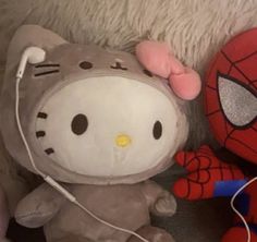 hello kitty and spider - man stuffed animals are laying next to each other