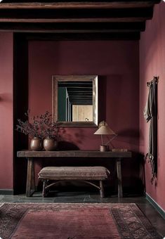 a room with a bench, mirror and vases on the table in front of it