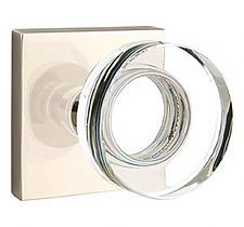 an image of a chrome plated door handle on a white wall mounted toilet paper dispenser