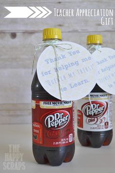 two bottles of dr pepper soda with paper tags attached to the top and one bottle is empty