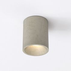 a light that is on the side of a wall with a white ceiling fixture in front of it