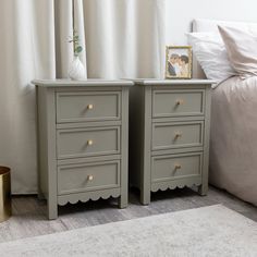 two gray dressers with gold handles in a bedroom next to a bed and white curtains