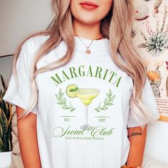 Infuse your casual wardrobe with a touch of vibrant flair with the Margarita Social Club Tee. Crafted on Comfort Color shirts, this exclusive tee is available in crisp white, playful pink, versatile ash, and classic ivory. Featuring a lively Margarita glass design, it's a must-have for those who appreciate laid-back style with a pop of personality. Elevate your look effortlessly with this statement tee, combining comfort and fashion for any occasion. Whether you're strolling along the beach or enjoying a social gathering, the Margarita Social Club Tee on Comfort Color shirts is your ticket to easygoing charm. Cheers to casual coolness! Design is Printed Direct to Garment. See Size Guide for Comfort Color Unisex Tee We recommend comparing these measurements against a shirt that you like the Summer T-shirt With Screen Print For Brunch, Summer Graphic Tee For Brunch, Summer Graphic Print T-shirt For Brunch, Summer Brunch Cotton T-shirt, Summer Cotton T-shirt For Brunch, Cotton T-shirt For Summer Brunch, Spring Brunch Graphic Tee T-shirt, Spring Brunch Graphic Tee Shirt, Spring Brunch Graphic Tee