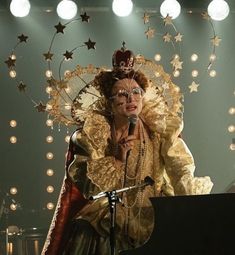 a woman in an elaborate costume is singing into a microphone