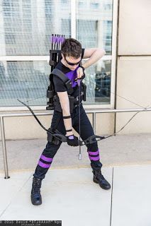 a man dressed in black and purple holding a bow